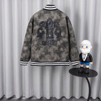 Back view of dark gray long-sleeve jacket with large ornate emblem and striped collar