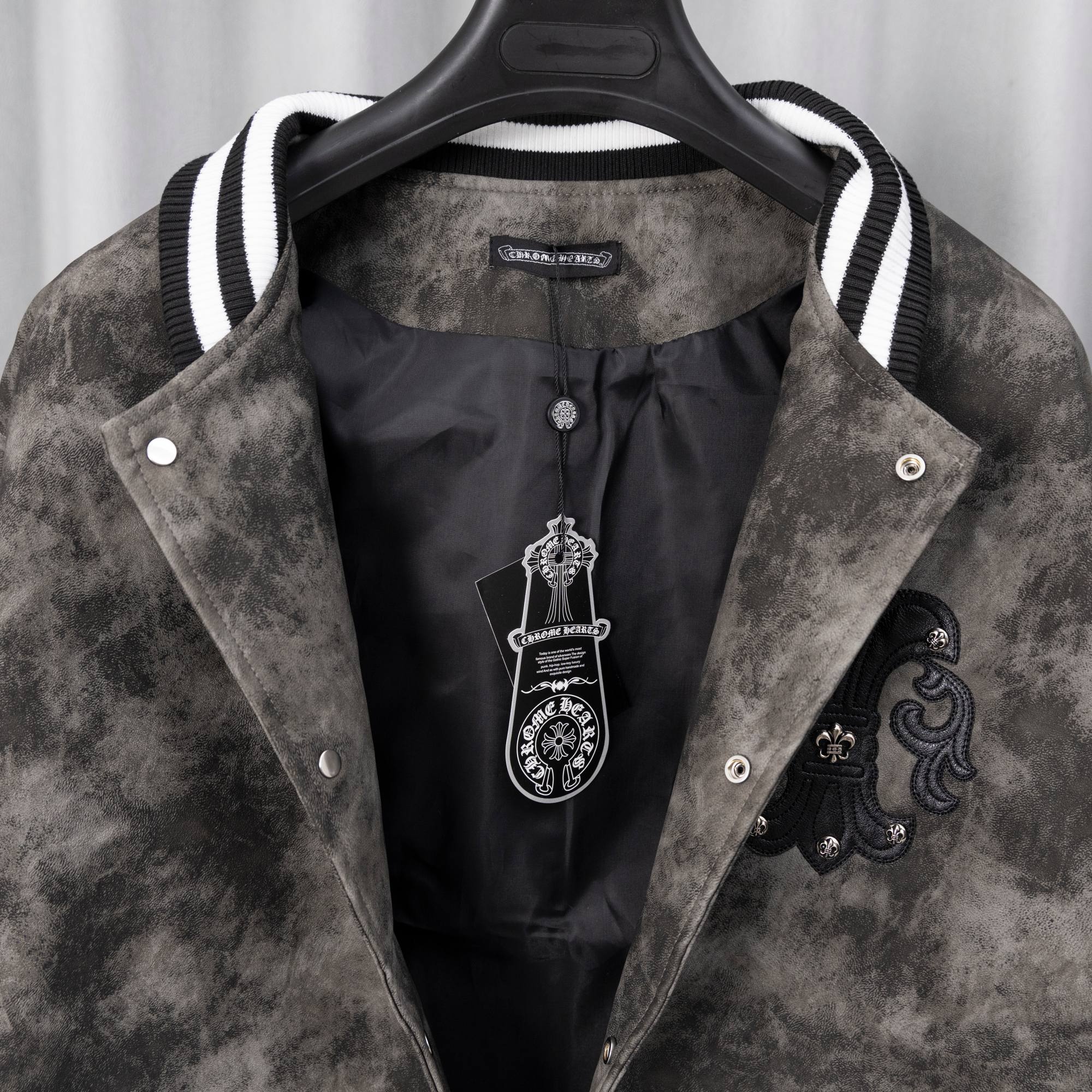 Long-sleeve jacket inside view with black inner panels and embroidered crest detail