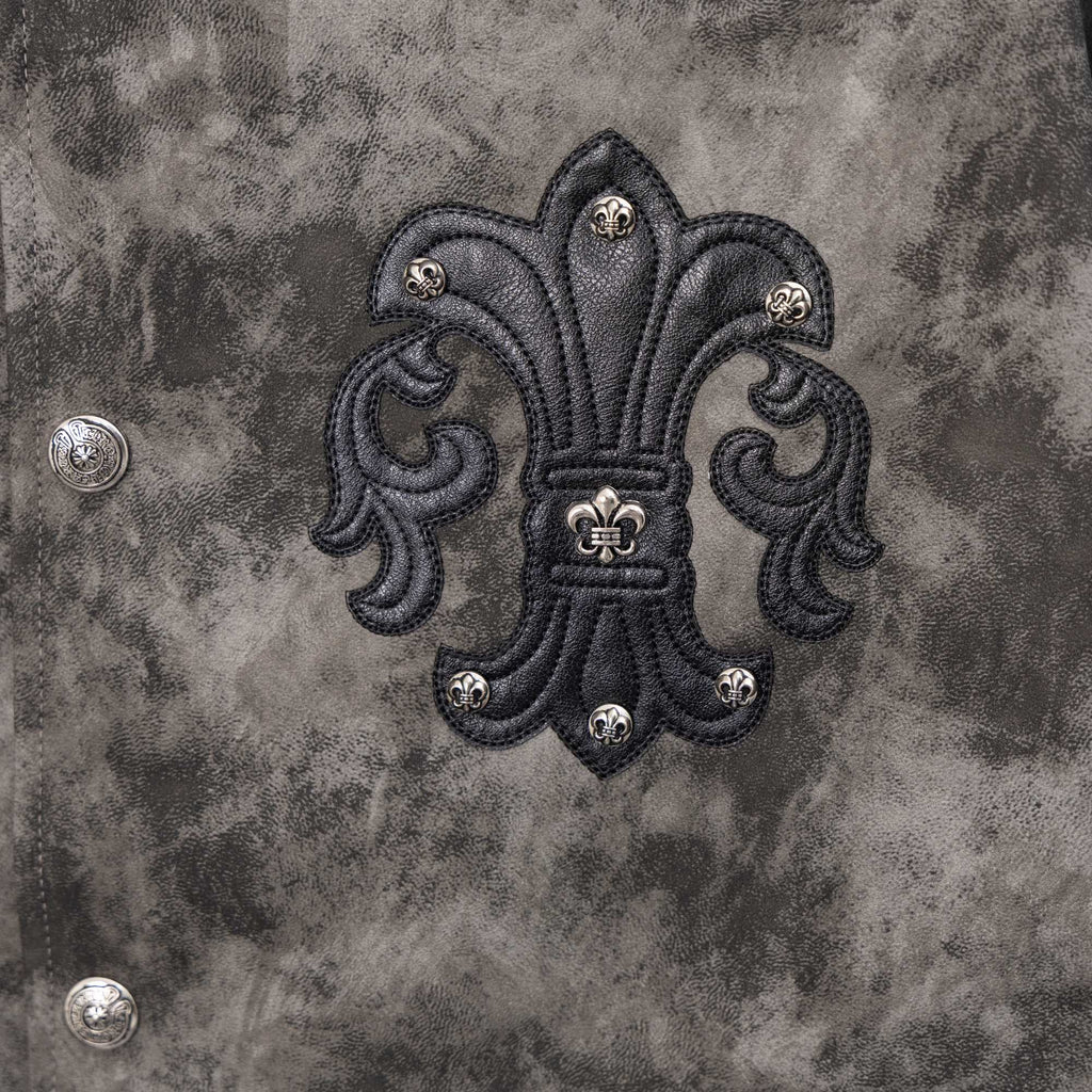 Close-up of dark gray jacket back with large black embroidered emblem and metal studs
