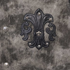 Close-up of dark gray jacket back with large black embroidered emblem and metal studs