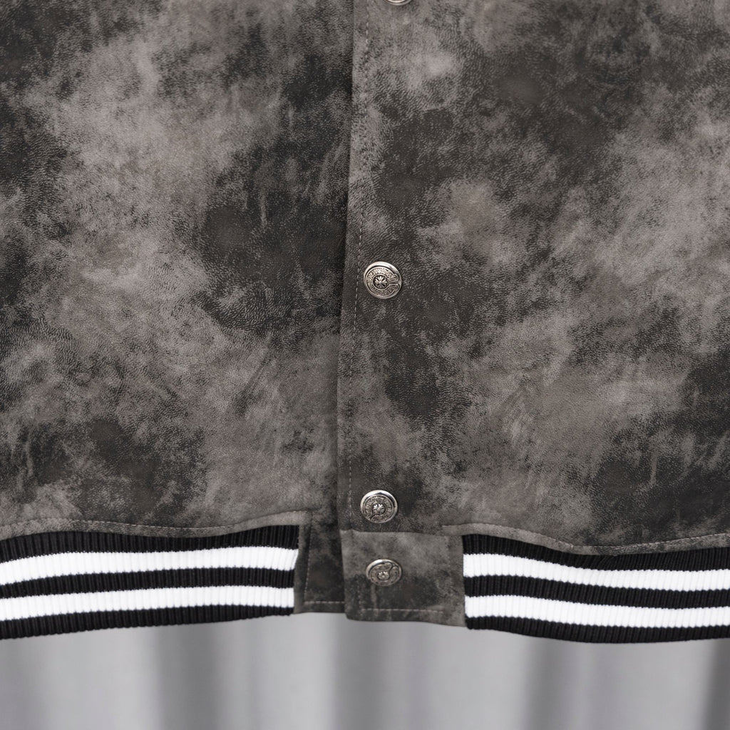 Close-up of dark gray jacket button placket with ribbed black-and-white hem stripe