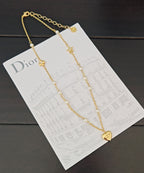 Gold-tone layered necklace with heart and star charms, pearl bead chain