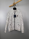 Long-sleeve zip jacket in white with repeating dark monogram print, ribbed cuffs.