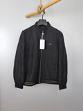 Dior long jacket in dark color, front zipper and stand collar, hanging on a rack