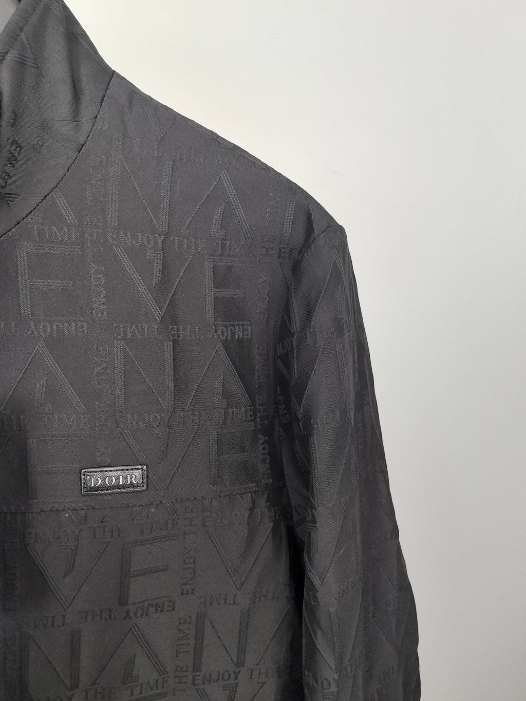 Dior long jacket chest area, textured pattern with small rectangular logo patch
