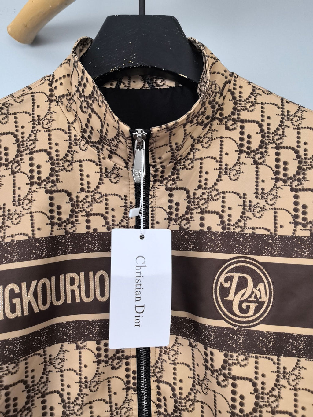 Beige patterned long zip jacket with stand collar and central zipper, close-up