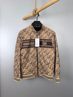 Beige long zip jacket with dark stripe, stand collar, ribbed cuffs on hanger