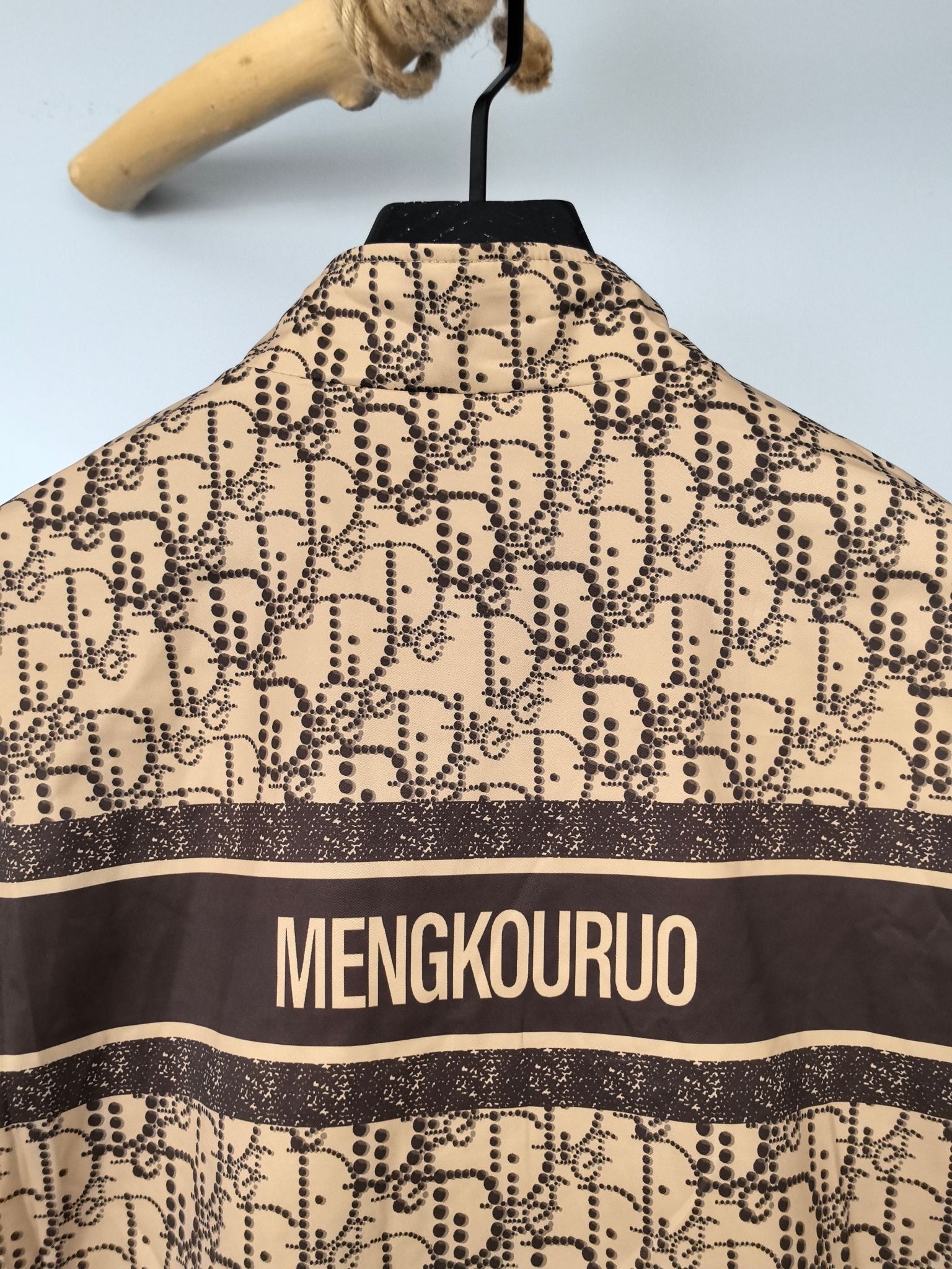 Beige long jacket back with MENGKOUROU stripe and patterned fabric, hanging