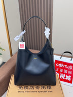 Dark blue hobo shoulder bag with top handle, hanging tags, and gold logo