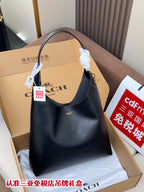Dark blue shoulder bag with top handle, hobo shape, and gold logo on front