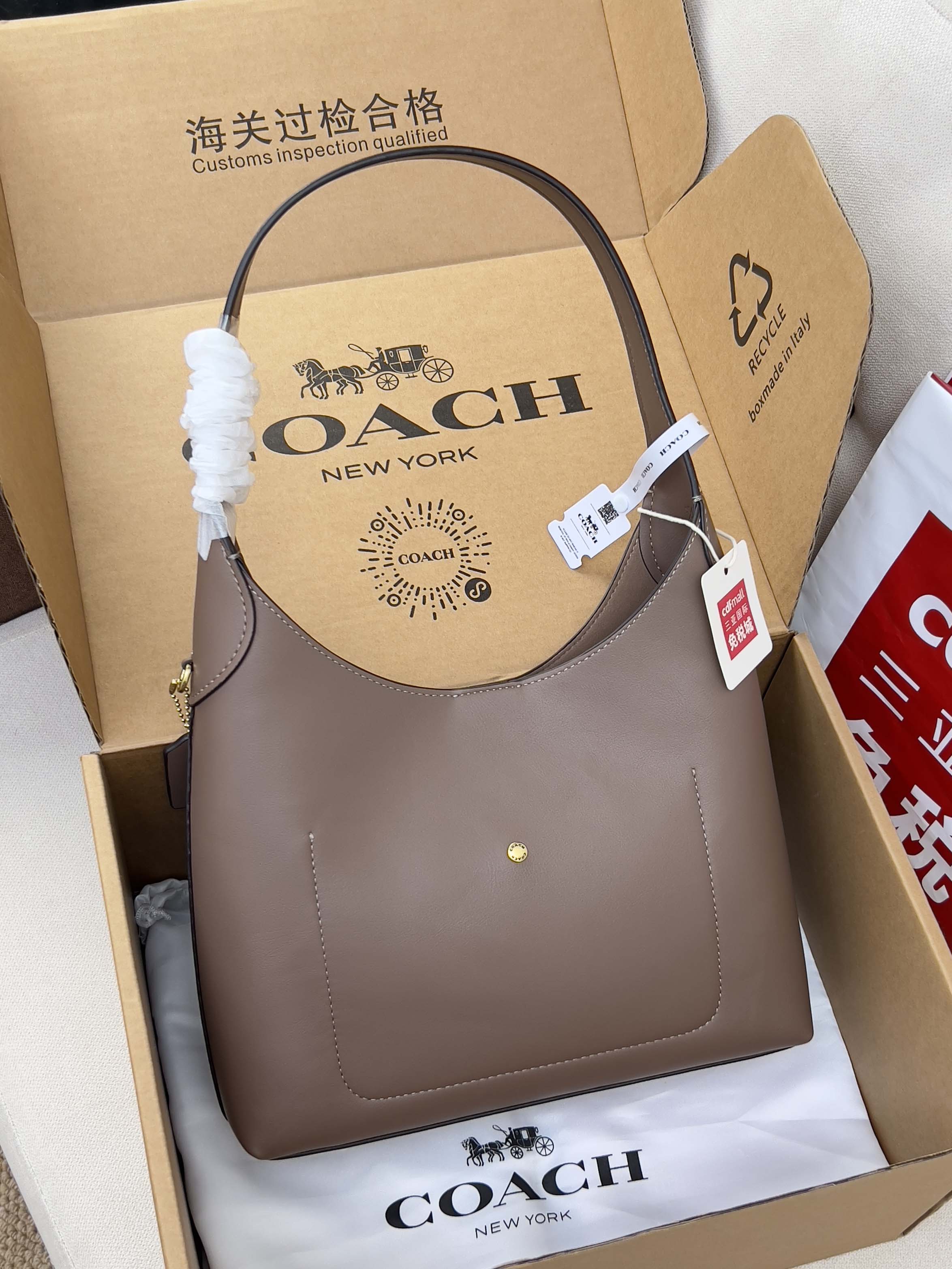 Taupe COACH handbag with curved top handles and small front logo detail