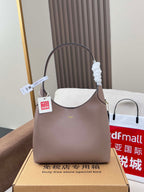 Taupe COACH handbag with curved top handles and front logo detail