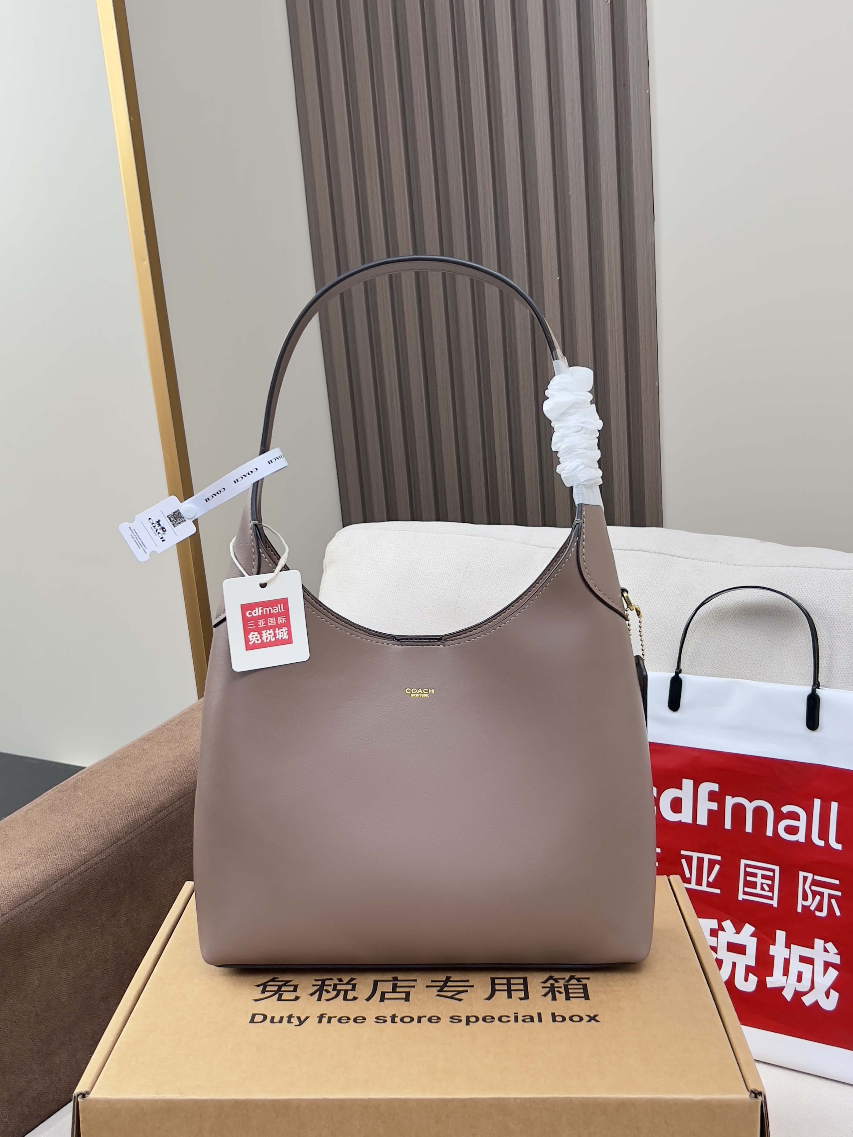 Taupe COACH handbag with curved top handles and front logo detail