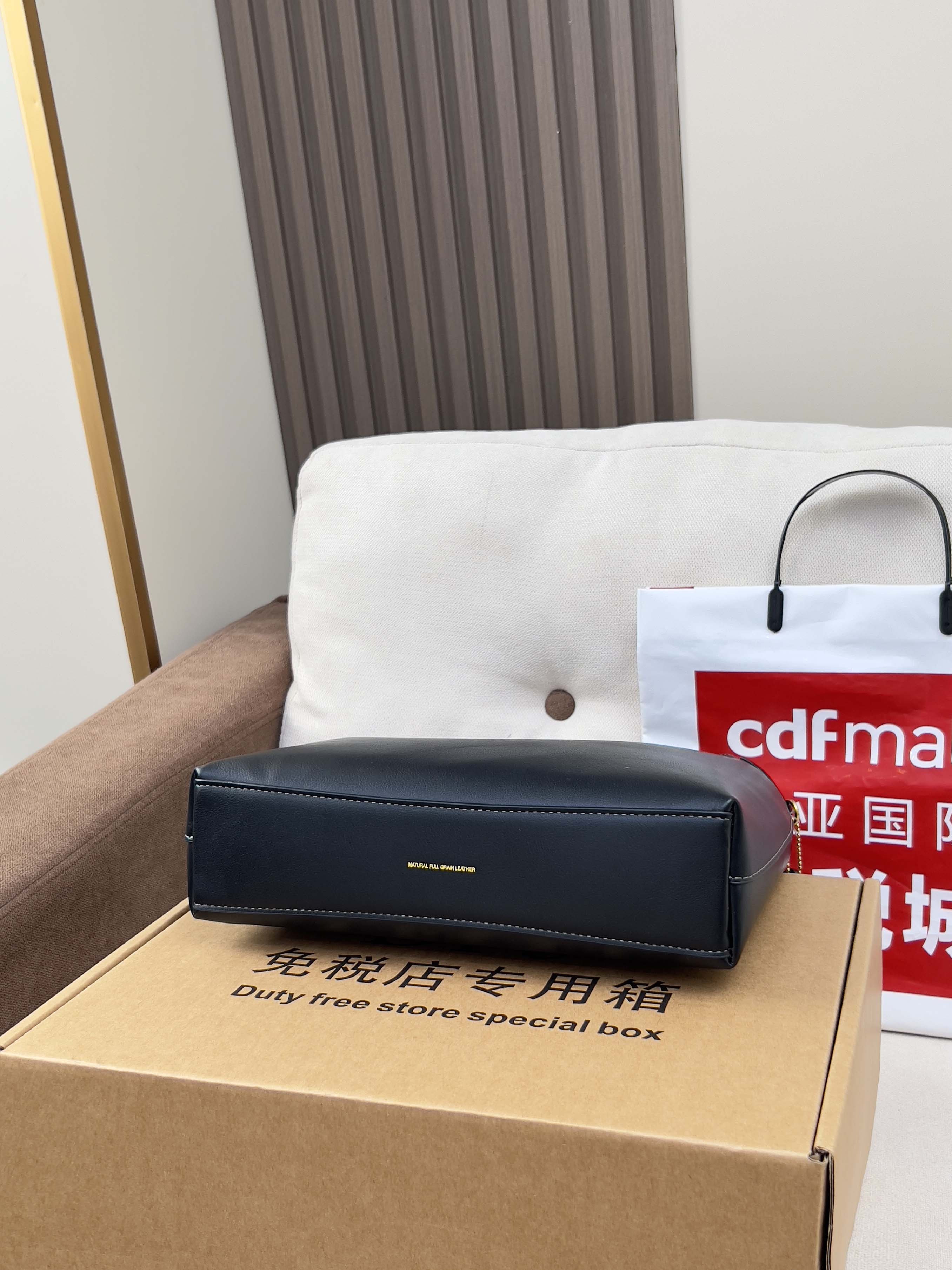 Dark blue leather handbag placed on a DFS duty free store special box
