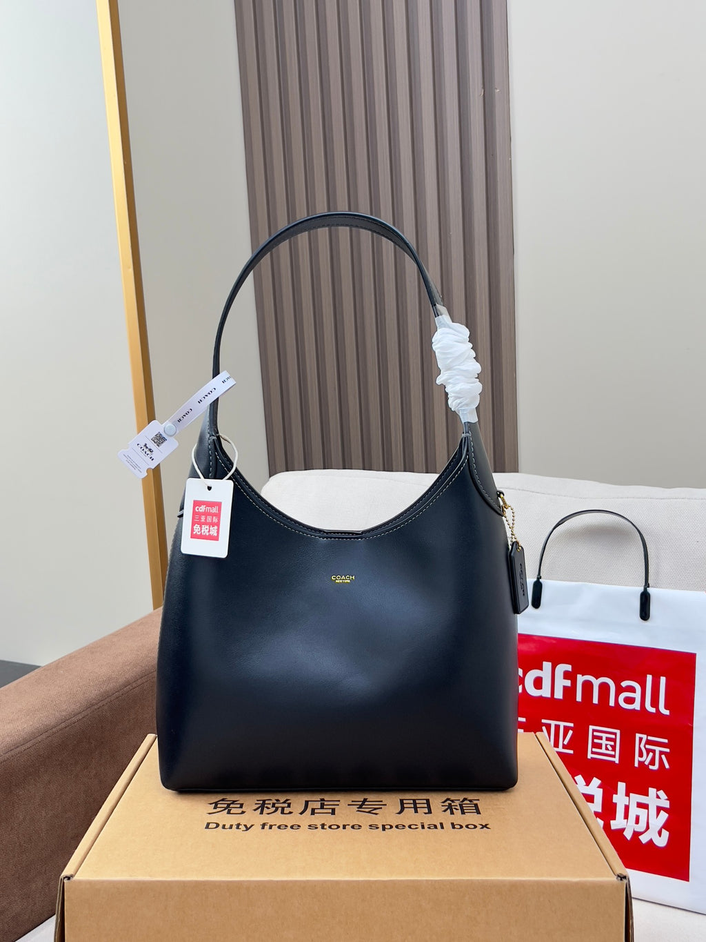 Dark leather handbag with arched top handle and side zipper pocket