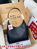Dark blue leather handbag with curved top handle and white pom accent