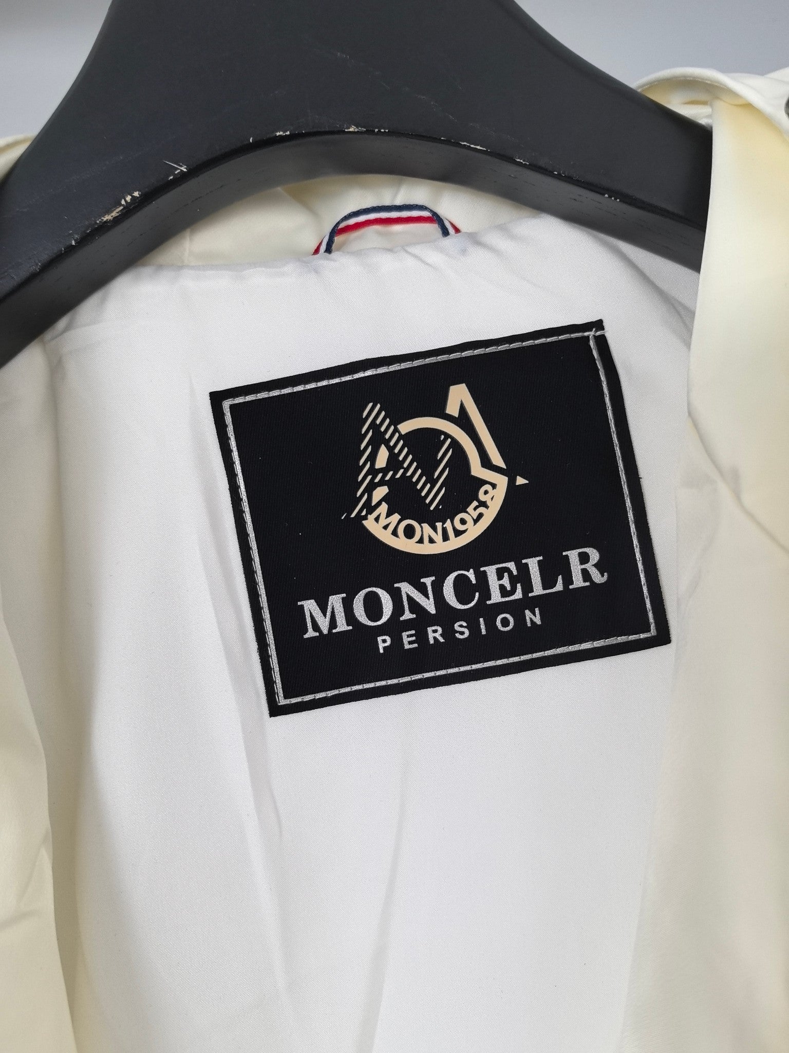 Moncler brand label on off-white hooded jacket interior