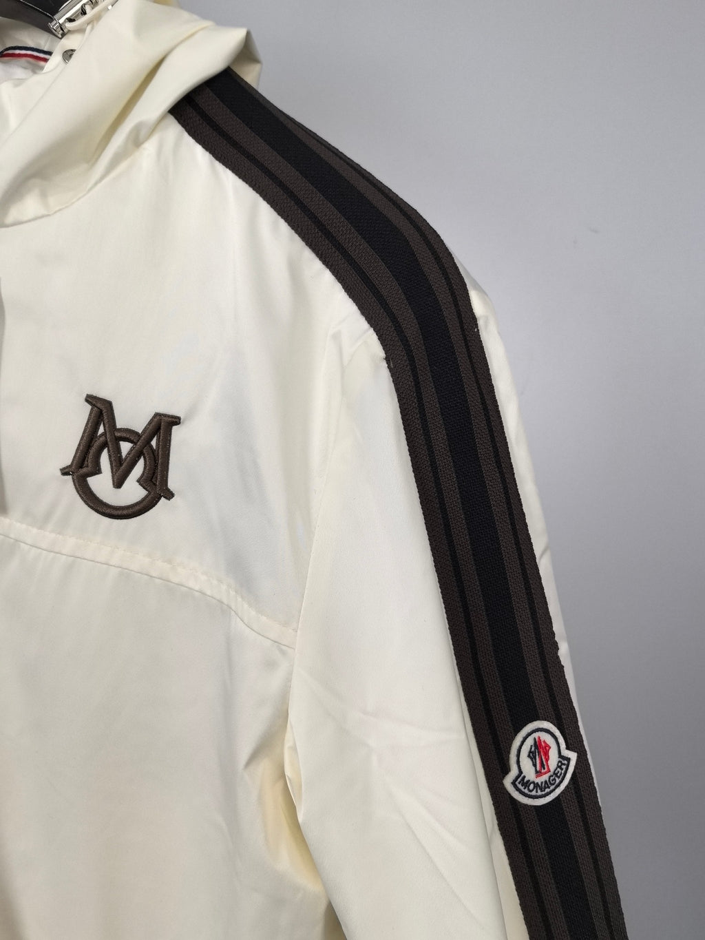 Moncler long jacket in off-white with black-and-gray striped sleeve and logo patch