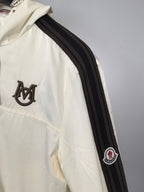 Moncler long jacket in off-white with black-and-gray striped sleeve and logo patch