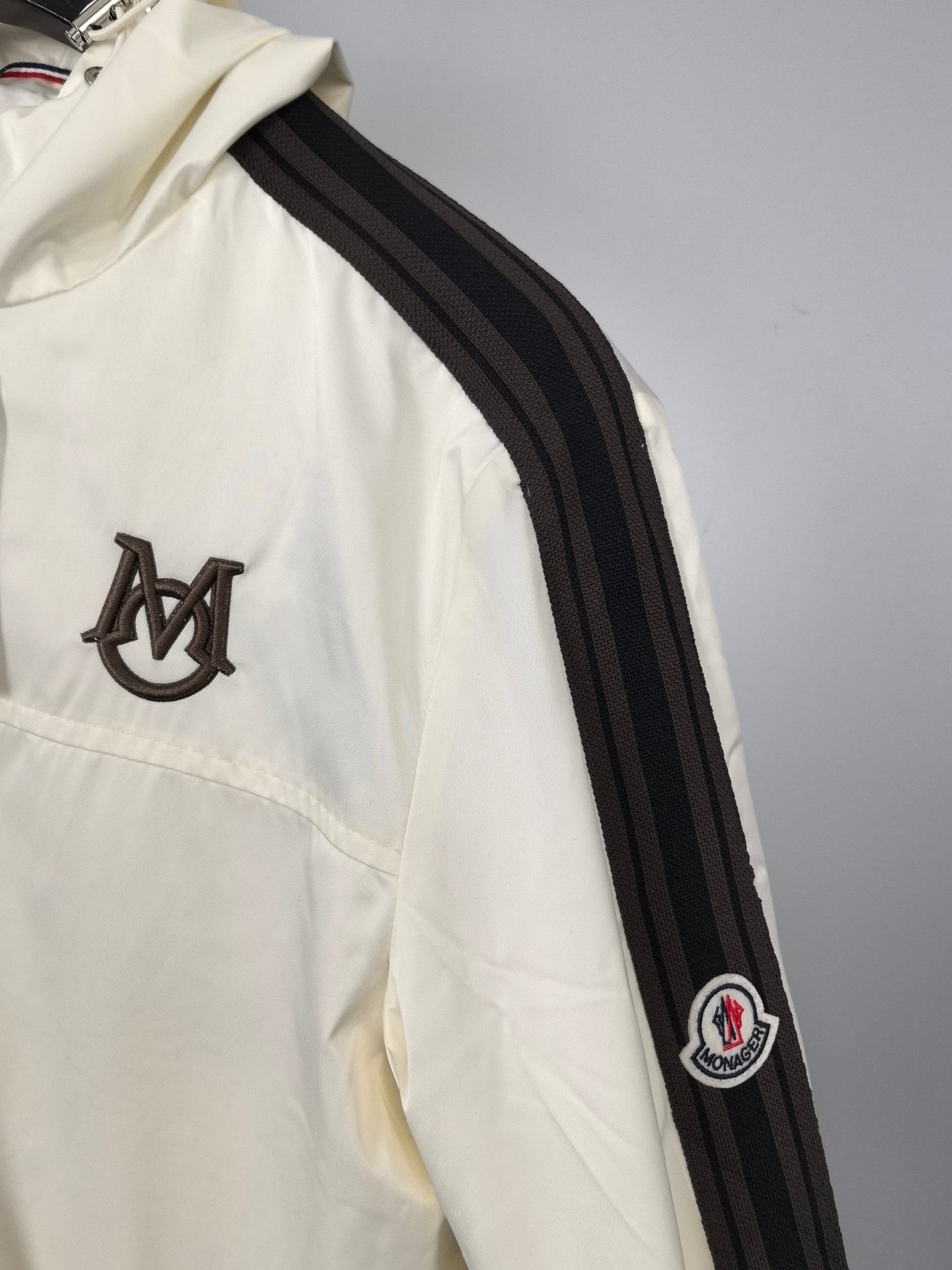 Moncler long jacket in off-white with black-and-gray striped sleeve and logo patch