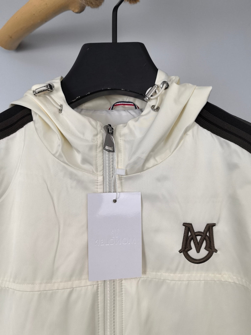 Moncler long hooded jacket in off-white with front zip and chest emblem