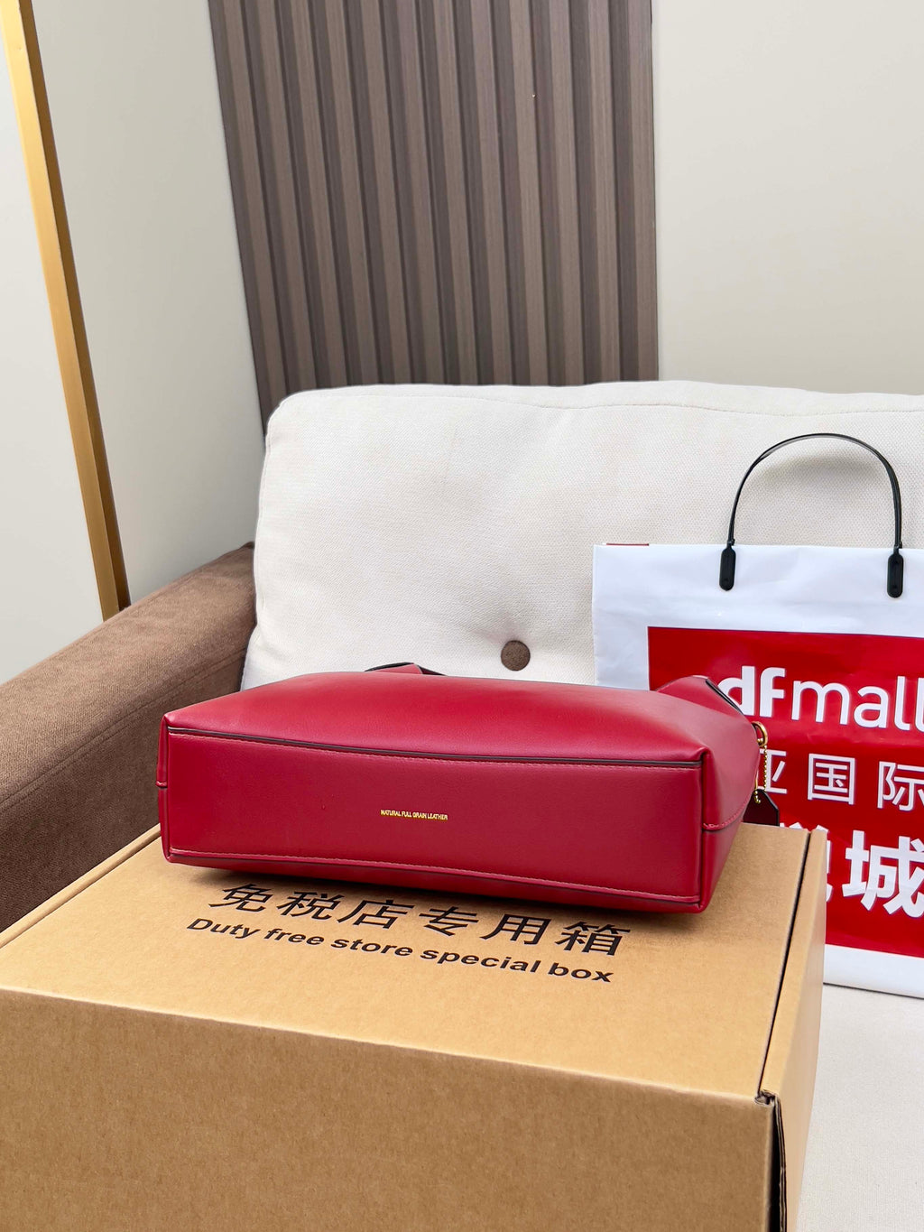 Red leather small bag on a box, with top handle