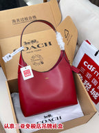 Red leather hobo bag with top handle, shown in gift box