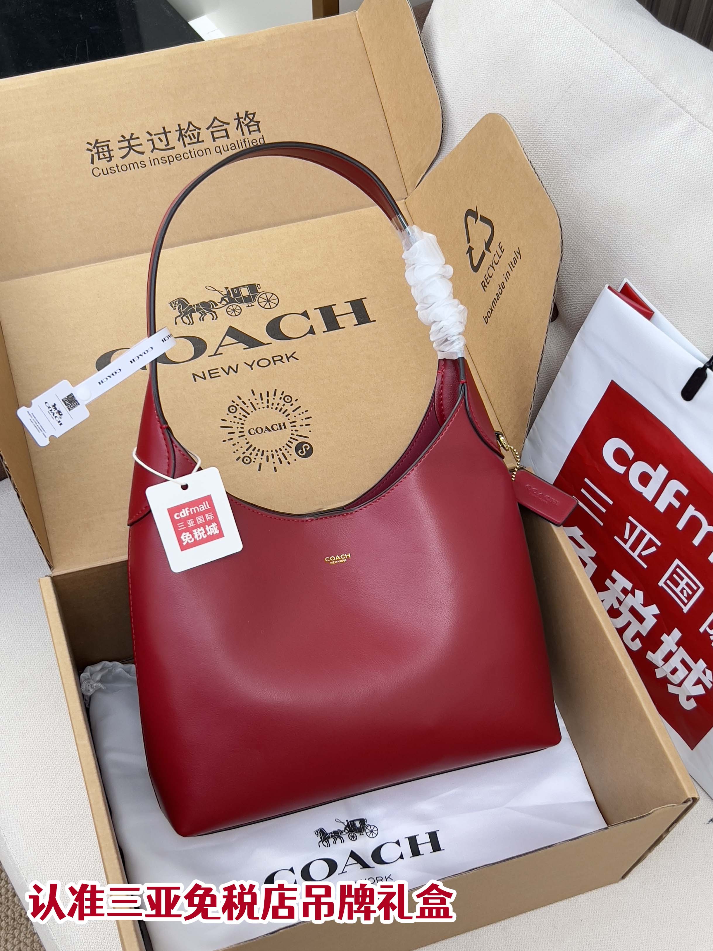 Red leather hobo bag with top handle, shown in gift box