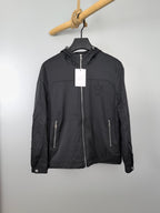 Black long hooded jacket with front zip and side pockets, hanging tag.