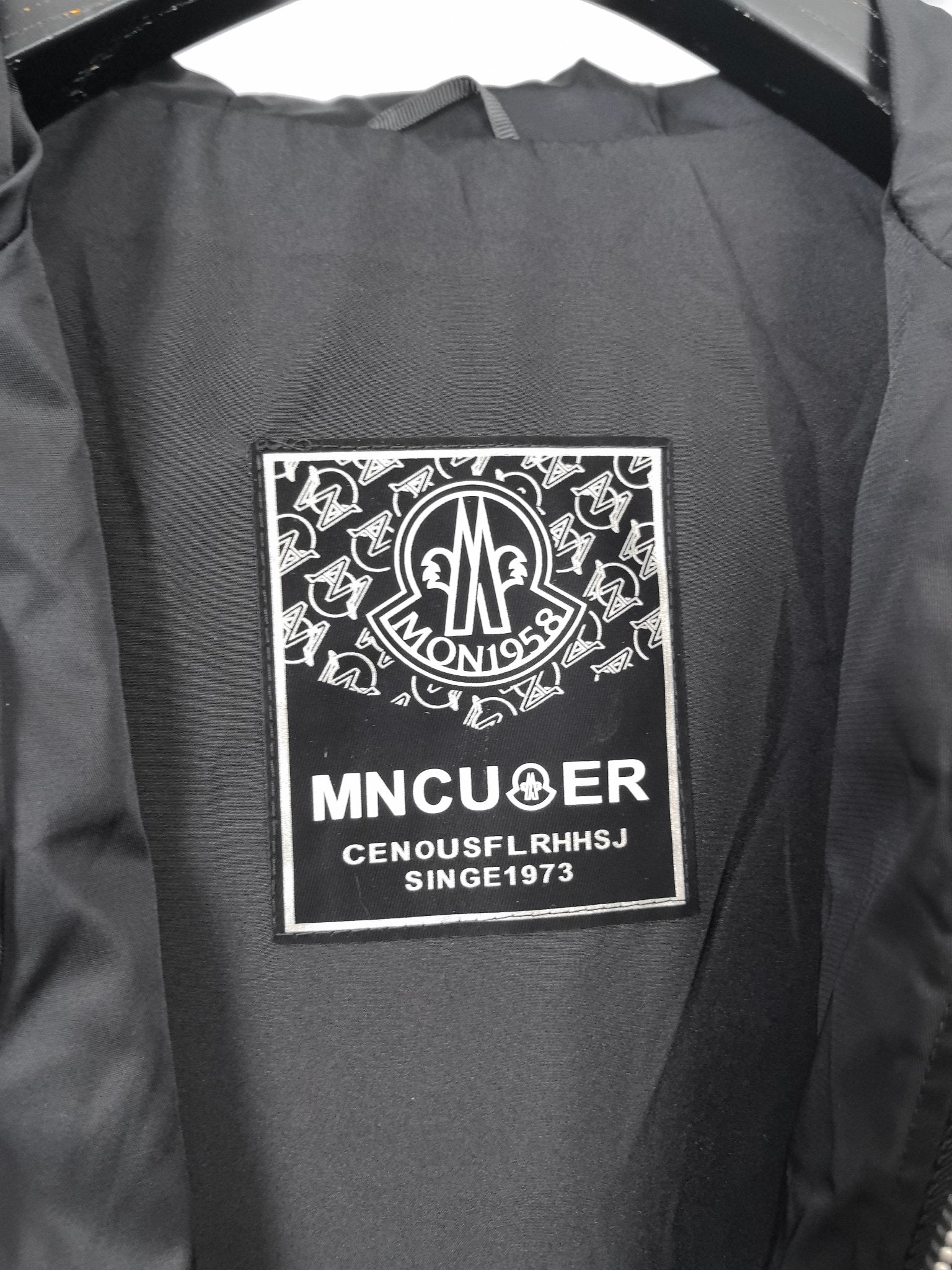 Black hooded jacket inner brand label patch on lining.