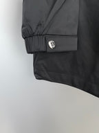 Black long jacket sleeve cuff with snap button and gathered hem.