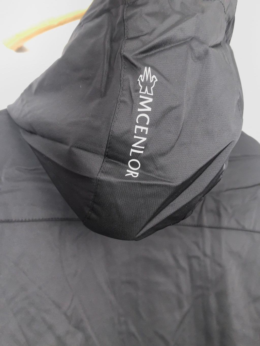 Black long jacket back with large white MONCLER logo print.