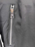 Black jacket front zipper close-up with metal pull and teeth.