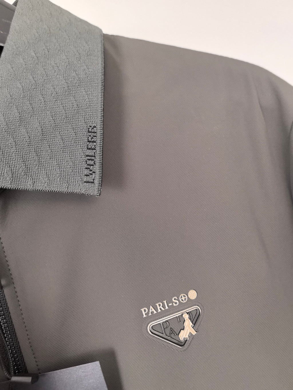 Prada jacket chest logo badge with triangular emblem on dark gray fabric
