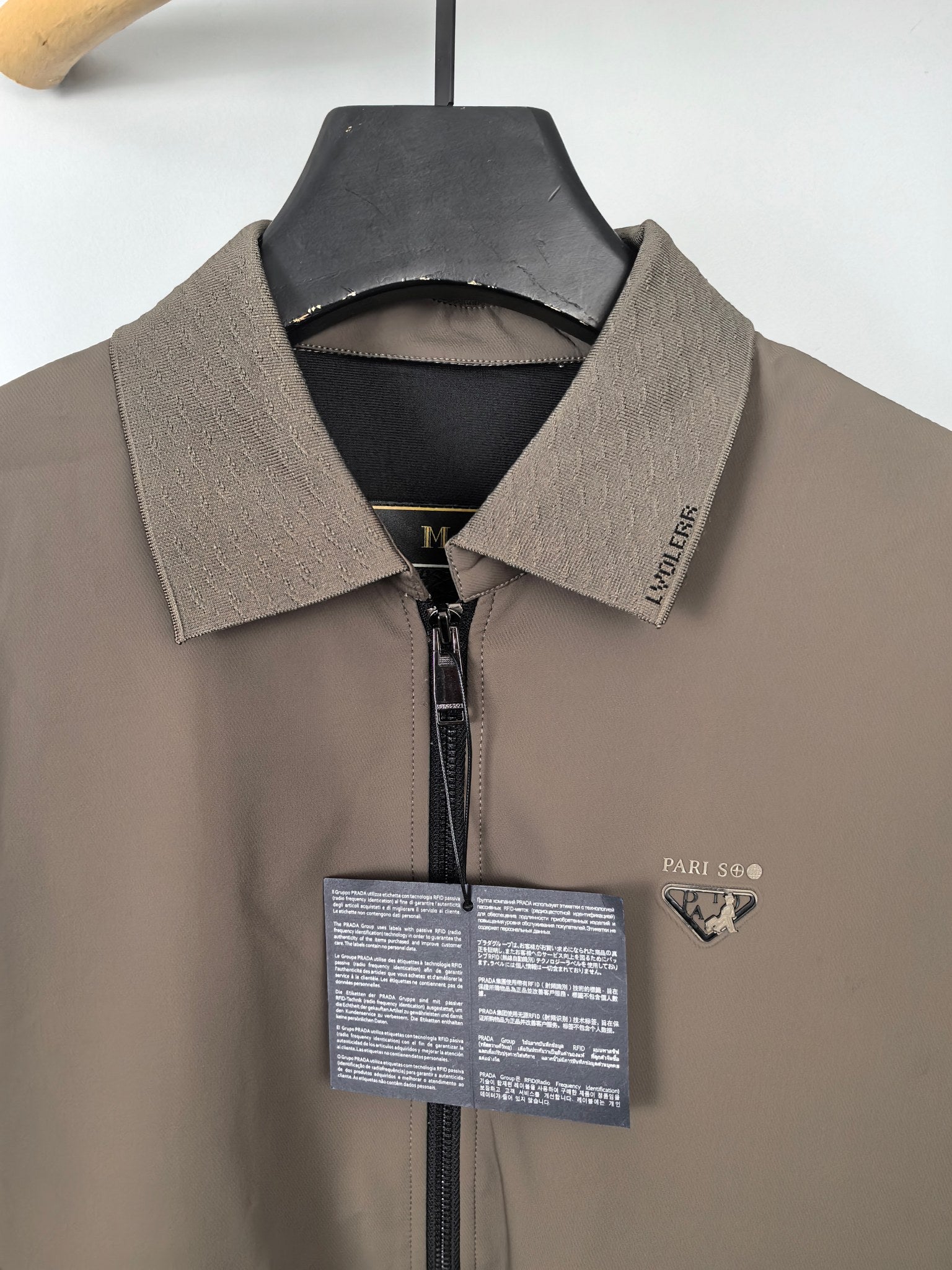 Men's Prada jacket collar close-up, taupe with black inner trim and zip front