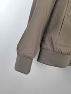 Men's Prada jacket sleeve close-up, taupe fabric with ribbed cuff at wrist