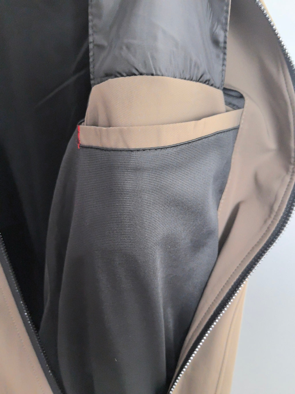 Men's Prada jacket open zip close-up, interior lining with taupe and gray pocket