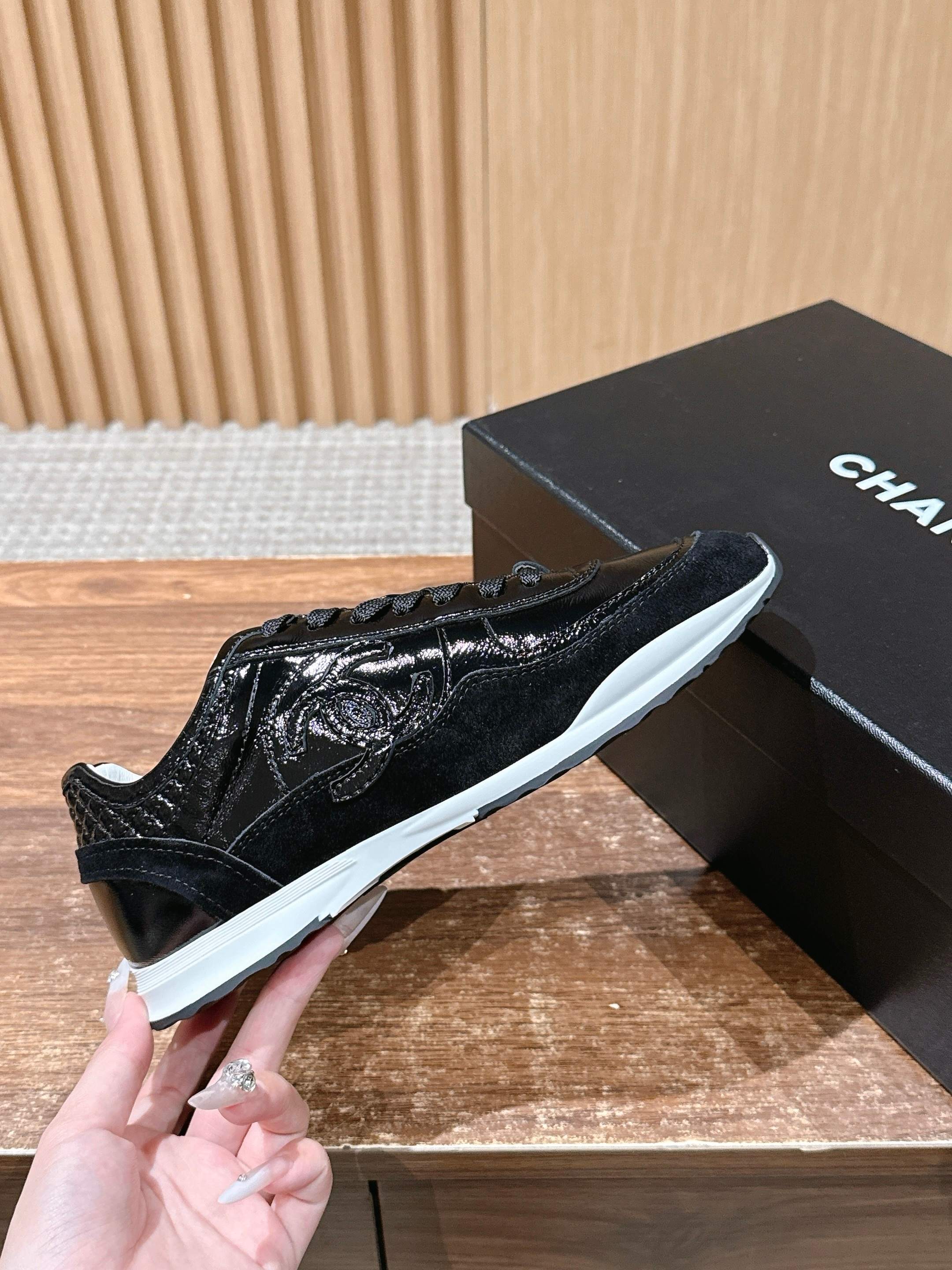 Black patent lace-up sneakers with textured shine, white sole, Chanel box