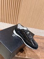 Black lace-up sneakers with white sole and Chanel-style logo detailing