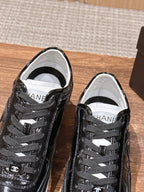 Black lace-up sneakers with white lining and Chanel logo on tongue