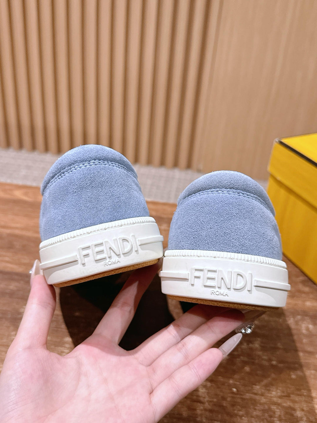 Light blue suede slip-on sneakers with blue fuzzy strap and FENDI logo on heel