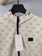 Cream long jacket close-up with GG monogram print, zipper, and logo patch