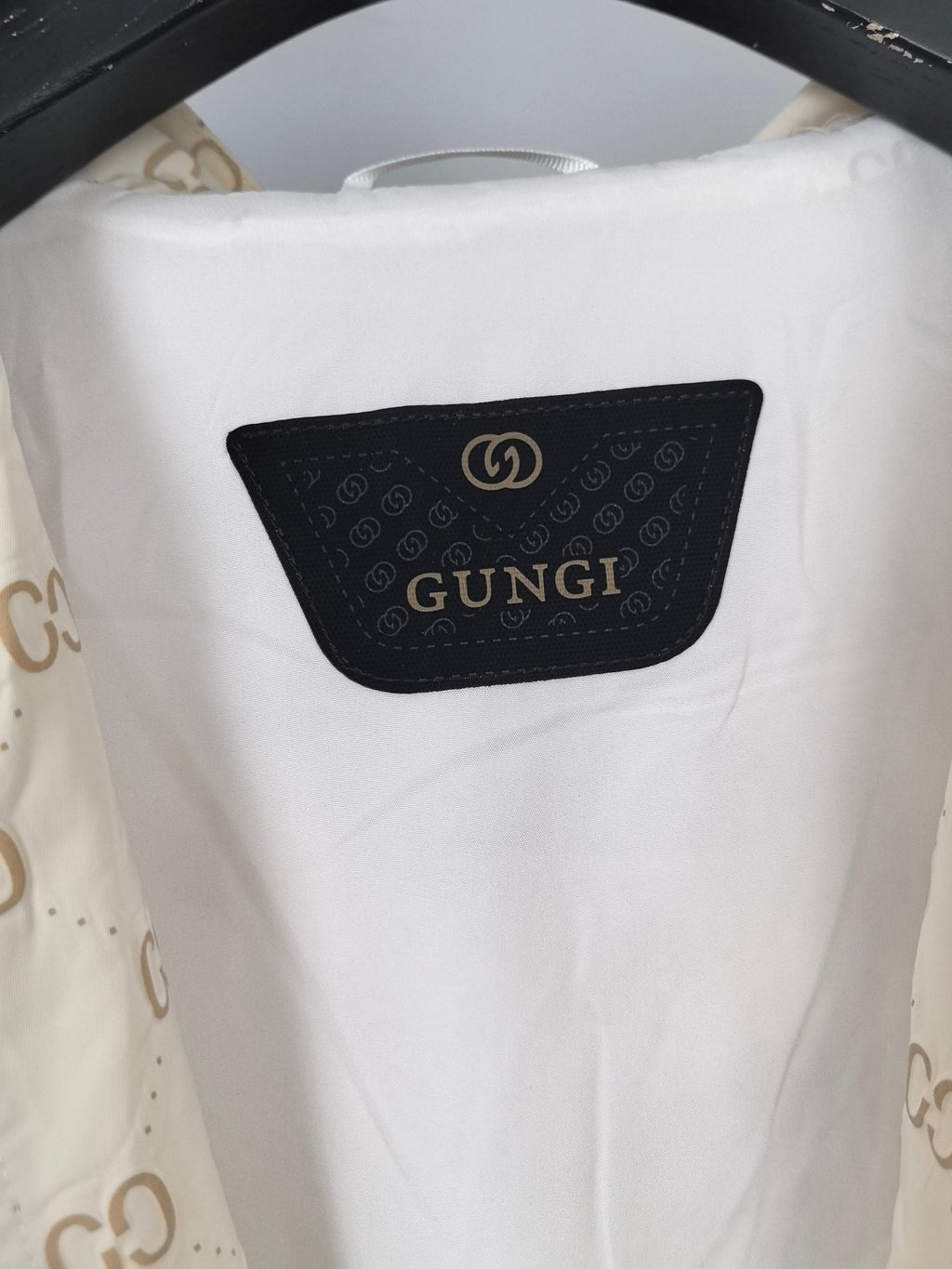 Cream long jacket back panel with black logo patch and GG monogram print