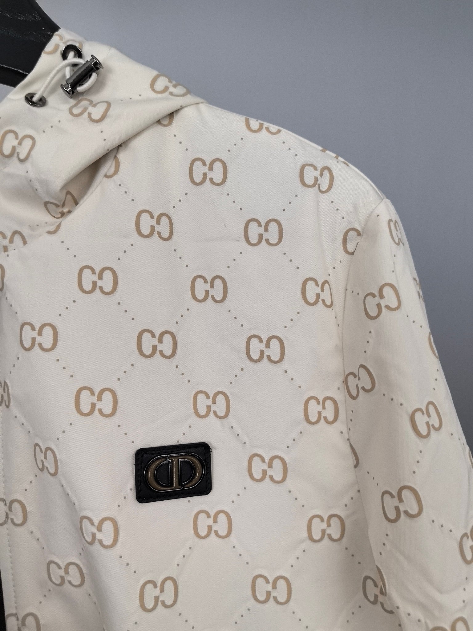 Cream long jacket fabric with repeating GG monogram and central logo patch
