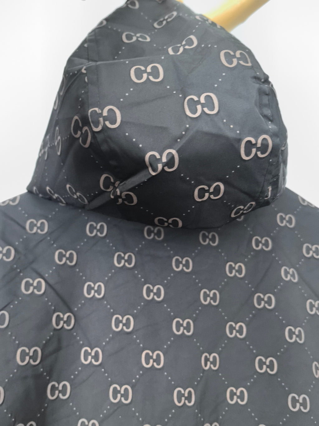Gucci hooded jacket, dark gray with repeating GG pattern, draped shoulder view