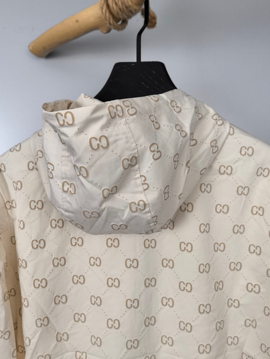 Cream long jacket back view with repeating GG monogram print and gathered hood
