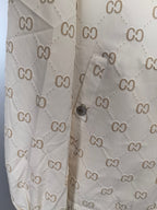 Cream long jacket front close-up with GG monogram print and snap detail
