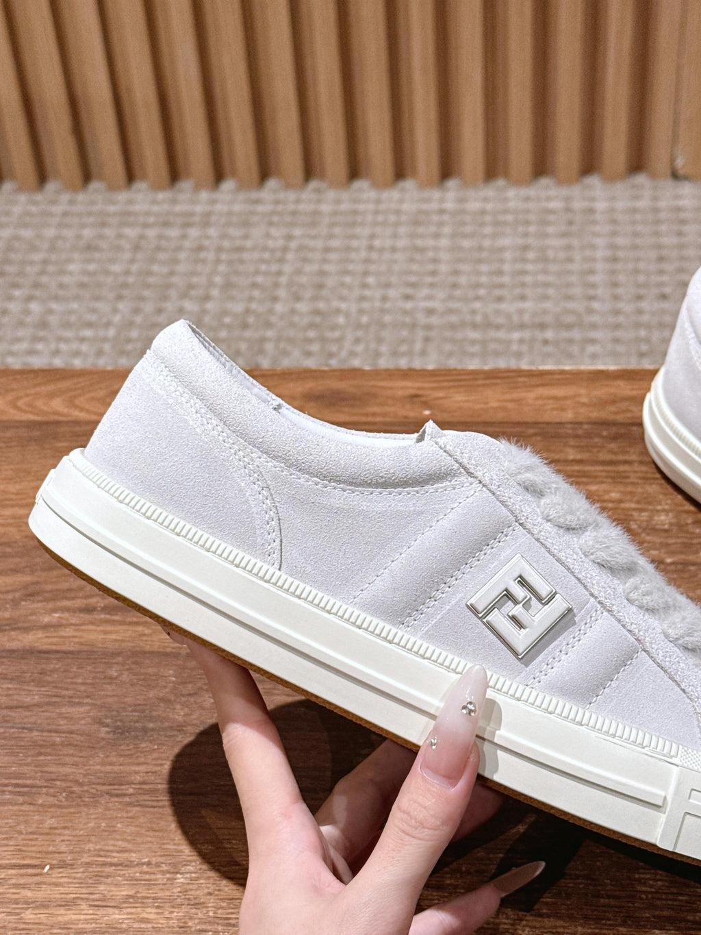 White Fendi sneakers, side profile with embossed F logo and lace-up upper