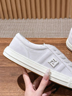 White Fendi sneakers, side profile with embossed F logo and lace-up upper