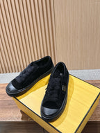 Black suede slip-on shoes with low rubber sole and stitched side panels